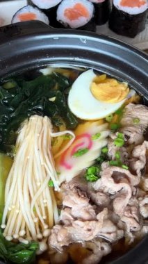 Tom Yum çorbası tofu, soba eriştesi, lahana, vişneli domates, taze soğan ve kişniş. Masa dönüşü. Yüksek kalite 4k görüntü