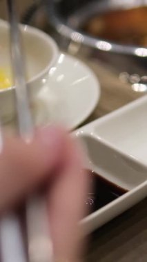 Siyah bir taş levha üzerinde lezzetli Japon suşisi ruloları. Yukarıdan bak. Çubuklar setten suşi alıp soya sosuna batırır. Farklı suşi türleri. Kapat.
