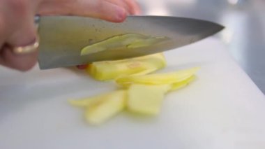 Dilimlenmiş zencefil kökü ahşap bir yüzeye düşer. Ağır çekim. Zencefil doğra.