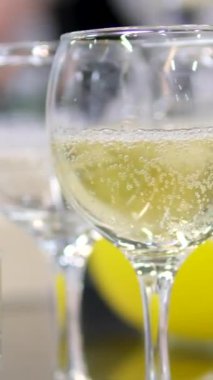 Genç bir kadın kristal bardağı beyaz şarapla alır ve tutar. Kız şampanya içiyor. Beyaz bornozlu bir kadın tatilde bir sabah kahvaltı yapar. 4k 