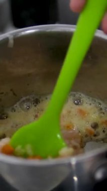 Soslu körili tavuk buğulama kabını büyük bir kaşıkla karıştırmak, Jamaika Karayip yemeği. Geleneksel defne yaprağı ev yemeği ruhu. Köri çorbası yap.