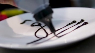 Beyaz bir tabakta çikolatalı üç katlı anahtar çiziyorum. Çikolatalı pasta vanilyalı dondurma ve mısır gevreği, çikolatayla süslenmiş ve beyaz tabağa bir Treble anahtarı çiz..