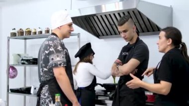 Profesyonel şef, yemek hazırlayan stajyerlerle konuşuyor. Vinnitsa Ukrayna 07.05.2024