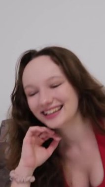 Yapay zeka. Genç kız yüksek sesle gülüyor, dirseklerine yaslanıyor, cep telefonuna bakıyor, sosyal oyun ağlarını seçiyor, oyunlar oynuyor. Yüksek kalite 