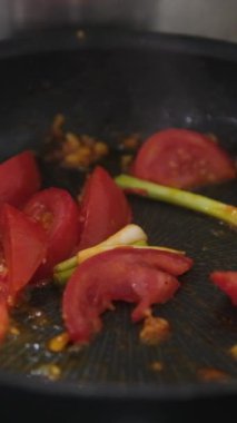 Zeytinyağı ve baharatlı tavada taze vişneli domates. Domates sosu pişiriyorum. Geleneksel İtalyan Meksika yemeği. Cafe için yüksek kalite stüdyo çekimi, restoran yakın çekim. Yüksek kalite