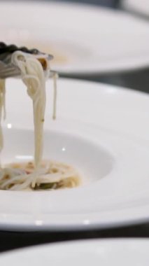 Kız mutfak için Asya mutfağı pilavı, erişteli siyah önlük pişirir ve tadar. Yüksek kalite 4k görüntü