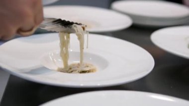Kız mutfak için Asya mutfağı pilavı, erişteli siyah önlük pişirir ve tadar. Yüksek kalite 4k görüntü