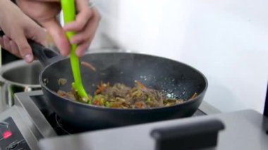 Hindi eti, erişte, paprika, mantar ve havuçlu waok yemek çubuklarıyla servis edilen siyah arka planda vermicelli udon. Yüksek kalite 4k görüntü
