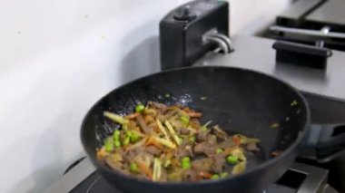 Hindi eti, erişte, paprika, mantar ve havuçlu waok yemek çubuklarıyla servis edilen siyah arka planda vermicelli udon. Yüksek kalite 4k görüntü