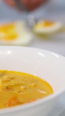 Mevsimlik sebze ve pastırma kremalı çorba taze otlar ve yumurtalarla süslenmiş ev yapımı lezzetli baharatlı çorba ahşap tahtada peçete ve kaşıklarla servis ediliyor. Yemek için hazır. 