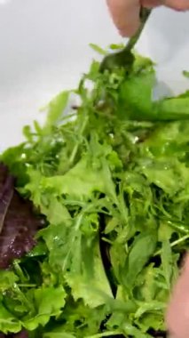 Salatayı yapraklardan hazırla. Romaine marulu, hindiba veya roka gibi farklı salata yapraklarının üzerine dökülen zeytinyağının yakın plan çekimi. Yüksek kalite