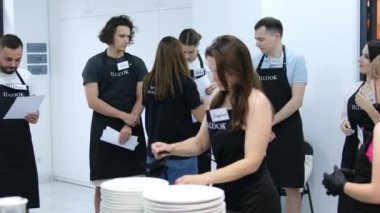 Yemek kursu. Mutfak sınıfı. Çok ırklı mutlu genç kadın öğrencilerden oluşan bir grup aşçılık okulunda aşçılık dersleri alıyor. Mutfak deneyimi stüdyosu. UCOOK Ukrayna Vinnitsa 08.04.2024