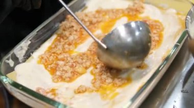 Mutfaktaki kadın lazanya hazırlıyor, peynir ekliyor kıyma ve pita ekmeği serpiştiriyor. Lazanya pişirme işlemi aşama aşama mutfakta hamur köftesi heykeli yapmak. Yemek pişiren kız.. 