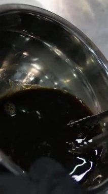 Kadın cam bir kasede tiramisu tatlısı hazırlıyor. Yanında da mutfak kasesi var. Adım adım tarif et. Tiramisu işlem yapıyor. 