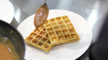 Waffle pişir. Waffle yapma süreci. Belçika waffle pişirme süreci. Waffle 'ların üzerine karamel serpiştir
