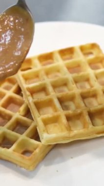 Waffle pişir. Waffle yapma süreci. Belçika waffle pişirme süreci. Waffle 'ların üzerine karamel serpiştir