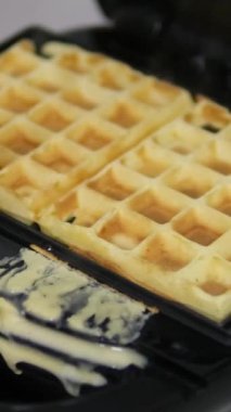 Waffle pişir. Waffle yapma süreci. Belçika waffle pişirme süreci. Waffle 'ların üzerine karamel serpiştir