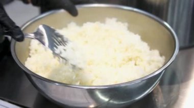 Kadın şef suşi yapar ve pirinç, kırmızı balık ve avokadodan rulo yapar. Yakından yemek pişirir. Suşi hazırlama süreci Master sınıfı. Adım adım Video seti