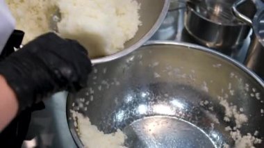 Kadın şef suşi yapar ve pirinç, kırmızı balık ve avokadodan rulo yapar. Yakından yemek pişirir. Suşi hazırlama süreci Master sınıfı. Adım adım Video seti