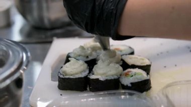 Kullan at. Fırında ekmek hazırlama işlemi. Japon suşi rulolarının adı Fırınlanmış Ebi. Restoranın mutfağında elle tutulan bir gaz ocağıyla peynirli suşi pişiren şefin yakın çekimi..