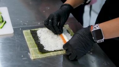 Yemek pişirme süreci, adım adım, Suşi tempura Eller siyah eldivenlere batırılmış rulo pirinç unundan yapılan tempura ve kızartma için nişasta ve çıtır bir Japon yemeği, üst görünüm.