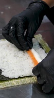 Yemek pişirme süreci, adım adım, Suşi tempura Eller siyah eldivenlere batırılmış rulo pirinç unundan yapılan tempura ve kızartma için nişasta ve çıtır bir Japon yemeği, üst görünüm.