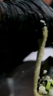 Yemek pişirme süreci, adım adım, Suşi tempura Eller siyah eldivenlere batırılmış rulo pirinç unundan yapılan tempura ve kızartma için nişasta ve çıtır bir Japon yemeği, üst görünüm.