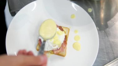 Benedict usulü yumurta haşlanmış yumurta soslu sandviç, yumurtalı Benedict ve Hollandaise sosu pişirme videosu. Yüksek kalite 4k görüntü