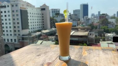 Ahşap masa sarı kokteylde. Sarı mango shake içmeye devam eder. Sıcak bir günde serinletici içecek. Cam Pipet ile tatlı mango suyu. Sabah kahvaltı sokak Cafe. Restoran İç tablo