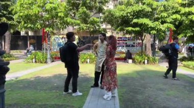 İyi kameralı Asyalı erkek fotoğrafçılar video çekimleriyle ilgili ana kursu çekiyorlar. Bir kız fotoğraf modeli üzerinde ulusal Vietnamlı kıyafetleri Ho Chi Minh Şehri Vietnam 08.22.2024