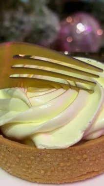 Beyaz mermer masada servis edilen bir dilim lezzetli limonlu turta ve çatalla yenen limonlu turta. Yüksek kalite 4k görüntü