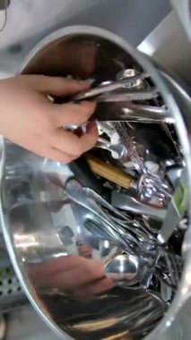 Mutfaktaki beyaz mermer masada bir sürü temiz bulaşık, bardak ve çatal bıçak takımı var. Havzadaki çatallar temizdir.