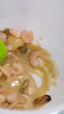 Beyaz bir kasede aşçı salata sosu ve pirinç vermicelli thai mutfağı için deniz ürünleri hazırlar. Soslu karides ve kalamar. Yüksek kalite 4k görüntü