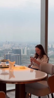 Ho Chi Minh şehrindeki lüks Vietnam tatilinde pahalı bir restoranda telefonu olan İngiliz kahvaltı kızı. Yüksek kalite 4k görüntü