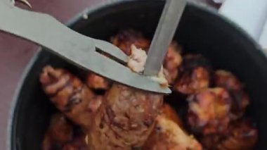 Adam şişlerden tabakta şiş çıkarıyor. Eti şişlemeden kaldır