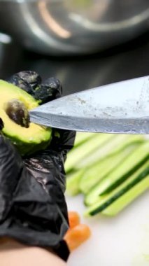 Avokadodan çukuru çıkar. Avokado 'yu avokadoya hazırlamadan önce onu çıkarıyorum.