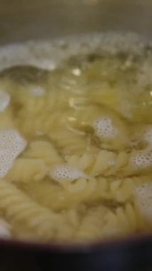Erkek şef haşlanmış suya makarna ekliyor. - Evet. Yüksek kalite 4k görüntü