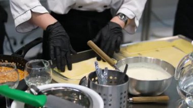 Biftek lazanyası, adım adım. Krem peynir tabakası. Video, ön manzara, kadın elleri, mermer mutfak masası arka planı. Adım adım lazanya pişiriyorum.