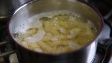 Erkek şef haşlanmış suya makarna ekliyor. - Evet. Yüksek kalite 4k görüntü