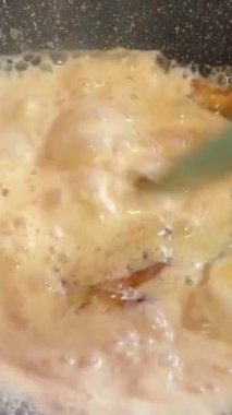 Şekerleme makinesi karamel hazırlamak için tavada şeker eritiyor. Evde karamel yapıyorum. Şekerleme ve kek kavramı. Şekere krema ekleyin.