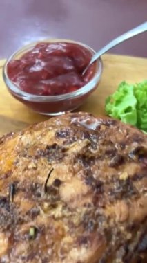 Şef taze ızgara et dilimliyor. Mutfaktaki ahşap kesme tahtasının üzerinde bıçakla. Yemekler yakınlaştırılıyor. Tahtada biftek.