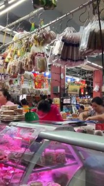 Kimliği belirsiz insanlar Ben Thanh pazarından şeker ya da kurutulmuş meyve alıyor. Şehrin en popüler turistik merkezlerinden birisidir. Vietnam Ho Chi Minh Şehri 09.06.2024