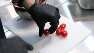 Salsa tarifli kadın mutfak bıçağıyla salata için kiraz domatesleri kesiyor. Yüksek kalite 4k görüntü