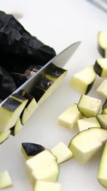 Patlıcan hazırlıyorum. Mutfak bıçağıyla kesme tahtasından patlıcan kesmek. Üst Manzara. Yakın plan. Yüksek kalite 4k görüntü
