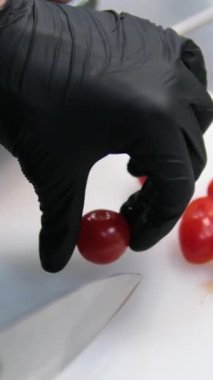 Salsa tarifli kadın mutfak bıçağıyla salata için kiraz domatesleri kesiyor. Yüksek kalite 4k görüntü