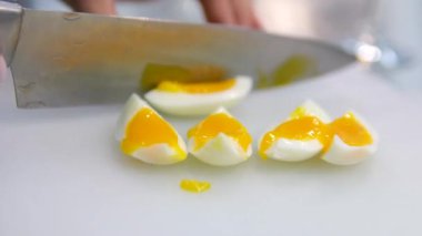 Yengeç salatası pişiriyorum. Kadın eli kaynamış yumurtaları panoda bıçakla kesiyor. Tatiller yaklaşıyor. Haşlanmış yumurta kesmek.