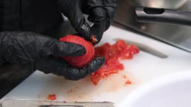 Domatesi çatalla delin. Üzerine kaynar su dökmeden önce domatesi kabuğunu soymak için hazırlıyorum. Bir domates kabuğunun üzerine kaynar su dök.