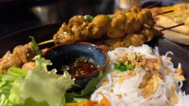 Bir sokak kafesinde akşam yemeği masanın üzerinde iki porsiyon şiş lik pirinç vermicelli sebzeli ve soslu plaj yemeği lüks restoran oteli dinlenmesi. zengin hayat
