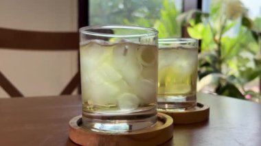Meyve dilimleri ve buz küpleriyle dönen şeftalili buzlu çay bardağı. Detoksifikasyon için sağlıklı ferahlatıcı limonata, tatlı tatlı meşrubat ya da yaz zamanı için soğuk aromalı içecek yavaş çekimde..
