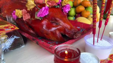 Domuzlar, Asya geleneğinde ev ruhuna tapınmak için baş kurban ederler. Çin Yeni Yılı domuz rostosu, dini tütsü, mum ve domuz rostosu. Yüksek kalite 4k görüntü